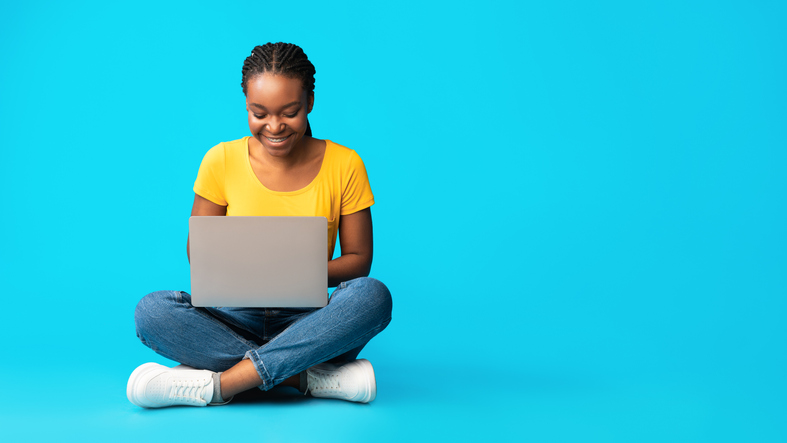 Lady sitting on the laptop on the floor 